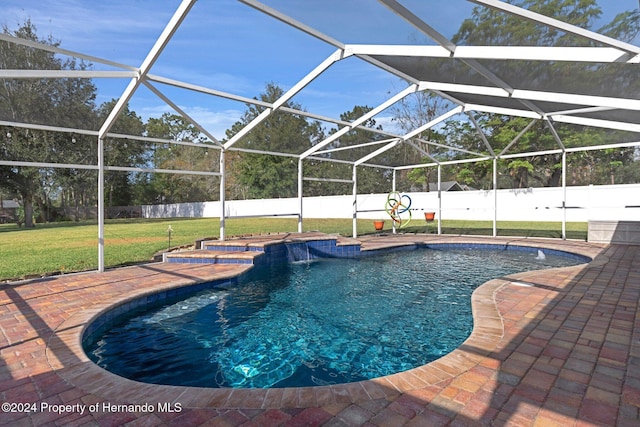 view of pool featuring a yard, pool water feature, a patio, and a lanai