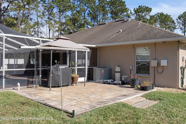 rear view of house with a patio, a lanai, and central air condition unit