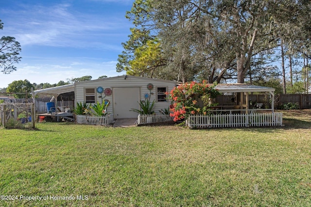 back of house featuring a lawn and a carport