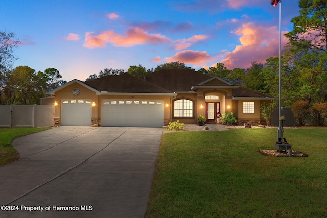 view of front of home featuring a garage and a lawn