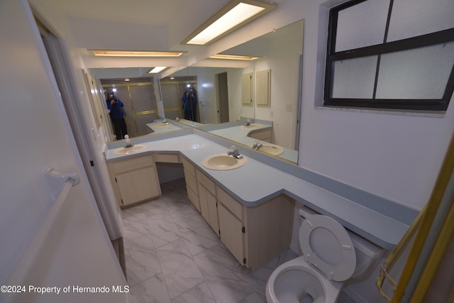 bathroom featuring vanity, toilet, and a shower with door