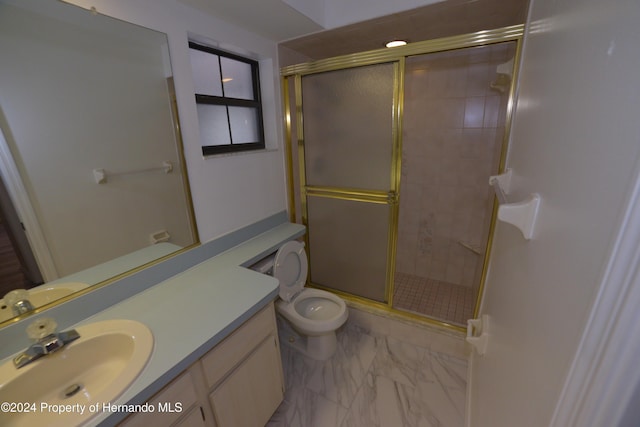 bathroom with a shower with door, vanity, and toilet