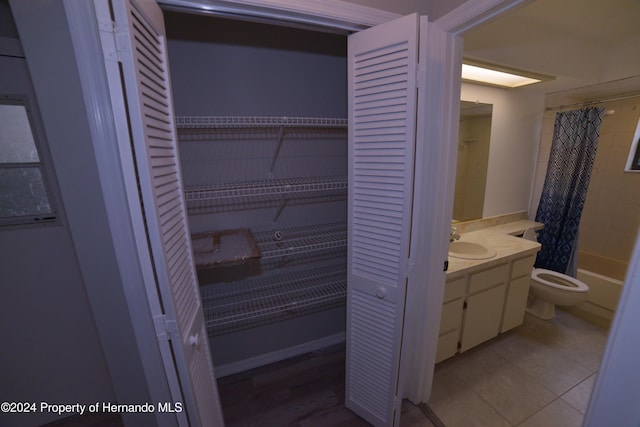 interior space featuring tile patterned floors, vanity, shower / bath combo, and toilet