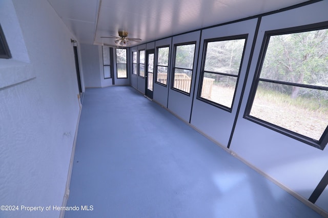 unfurnished sunroom featuring ceiling fan