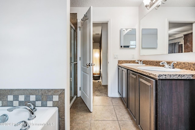 bathroom featuring tile patterned flooring, vanity, a textured ceiling, and plus walk in shower