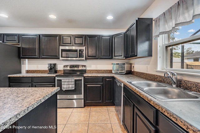 kitchen with sink, light tile patterned floors, and stainless steel appliances