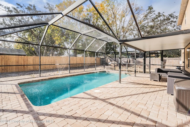 view of pool with a lanai, a patio area, and central air condition unit