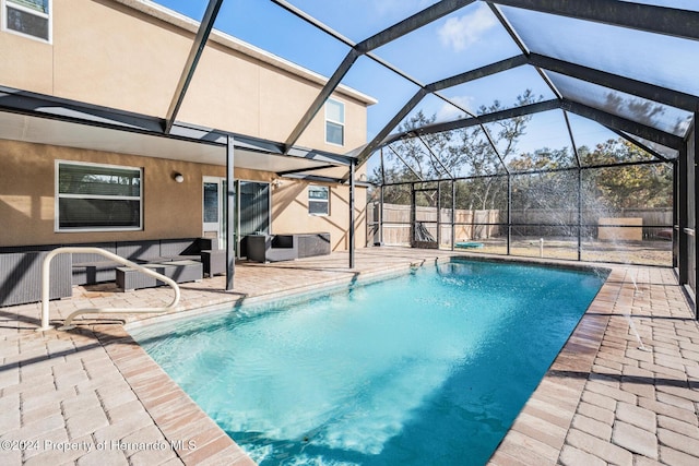 view of pool with a patio and glass enclosure