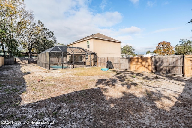 rear view of house featuring a lanai and a swimming pool