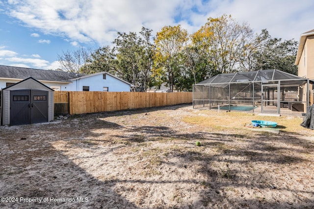 view of yard featuring a fenced in pool, glass enclosure, and a patio