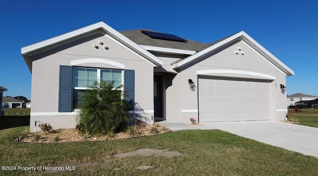 ranch-style home featuring solar panels, a garage, and a front yard