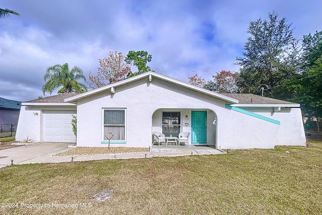 single story home with a porch, a garage, and a front yard