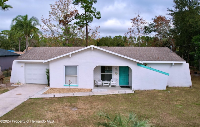 ranch-style home with a porch, a garage, and a front lawn