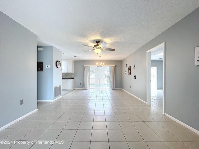 unfurnished living room featuring light tile patterned floors and ceiling fan with notable chandelier