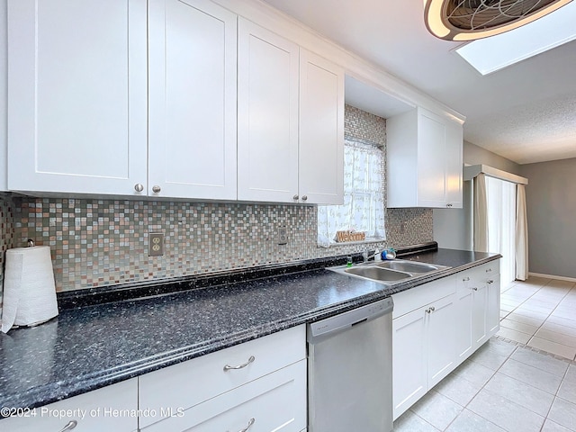 kitchen featuring dishwasher, sink, light tile patterned floors, decorative backsplash, and white cabinets