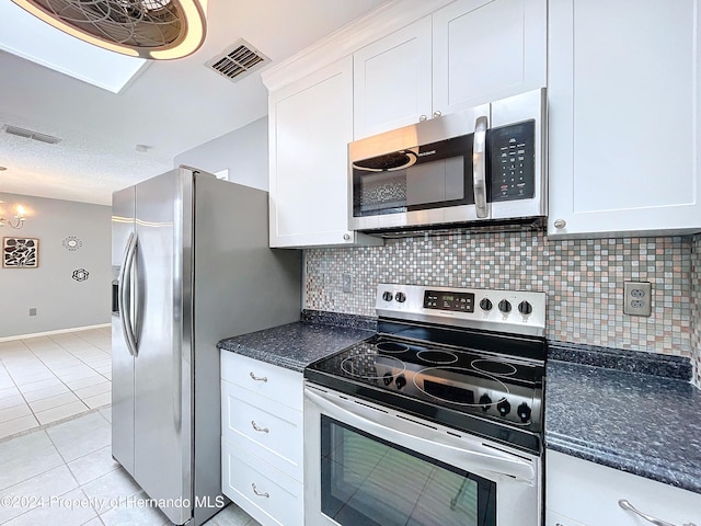 kitchen with white cabinets, decorative backsplash, light tile patterned floors, and appliances with stainless steel finishes