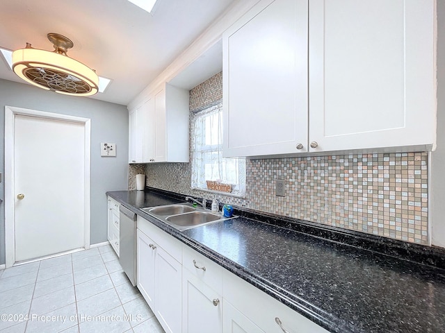 kitchen featuring decorative backsplash, sink, light tile patterned floors, dishwasher, and white cabinets