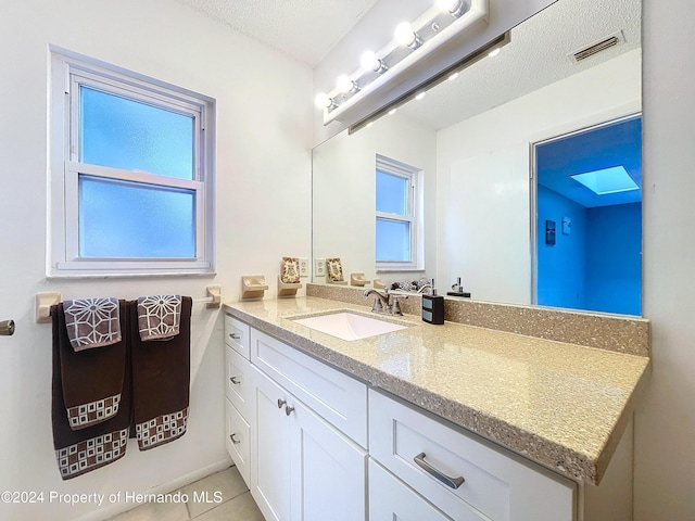 bathroom featuring tile patterned floors, vanity, and a textured ceiling