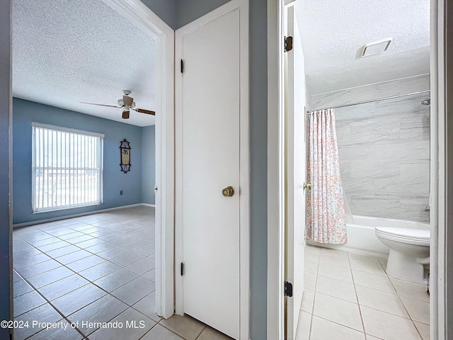 hallway with light tile patterned floors and a textured ceiling