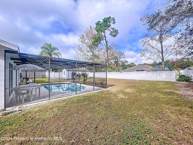 view of swimming pool featuring a lawn, a lanai, and a patio