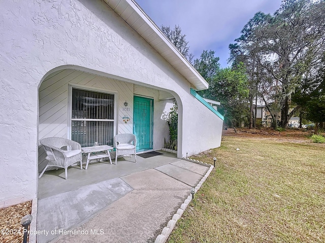 doorway to property featuring a lawn