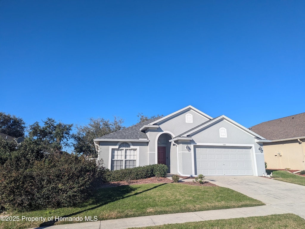 ranch-style house featuring a front lawn and a garage