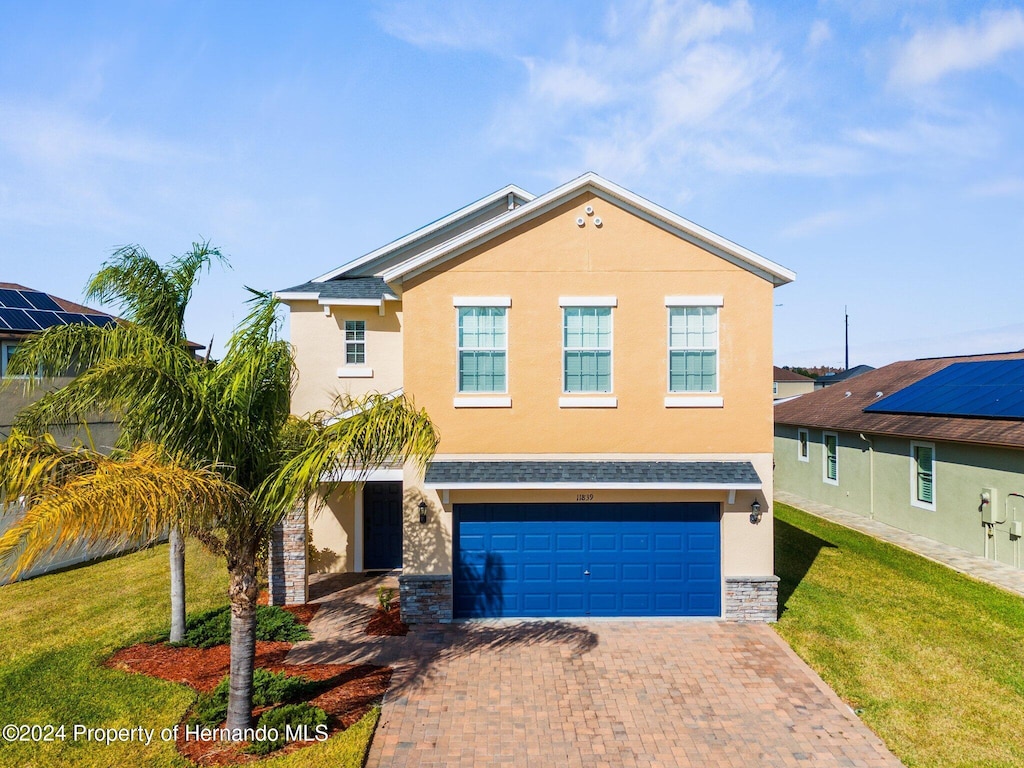 view of front facade featuring a front yard and a garage