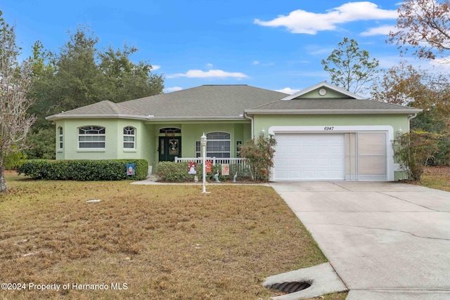 ranch-style home with a porch, a garage, and a front lawn