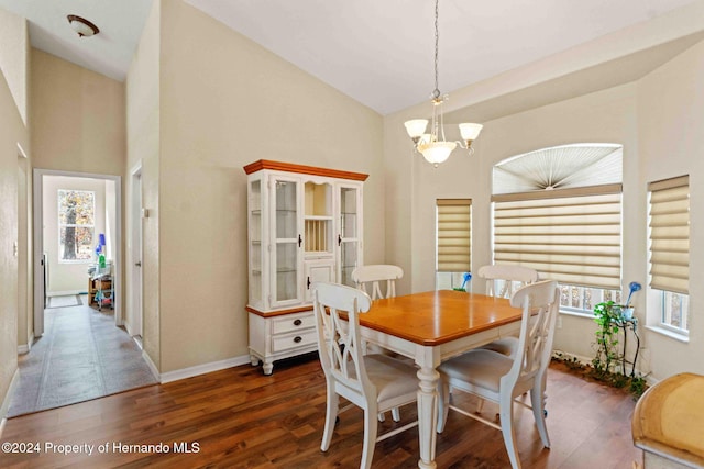 dining room featuring vaulted ceiling, dark hardwood / wood-style floors, and an inviting chandelier