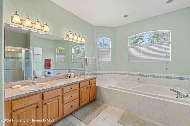 full bathroom featuring tile patterned floors, vanity, shower with separate bathtub, and toilet