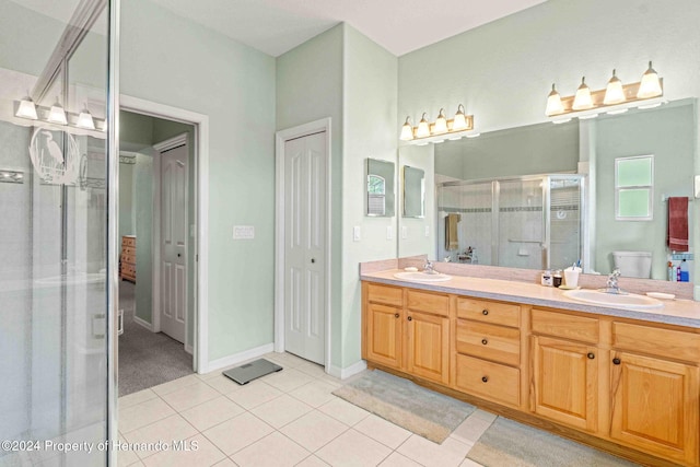 bathroom with toilet, vanity, tile patterned floors, and walk in shower