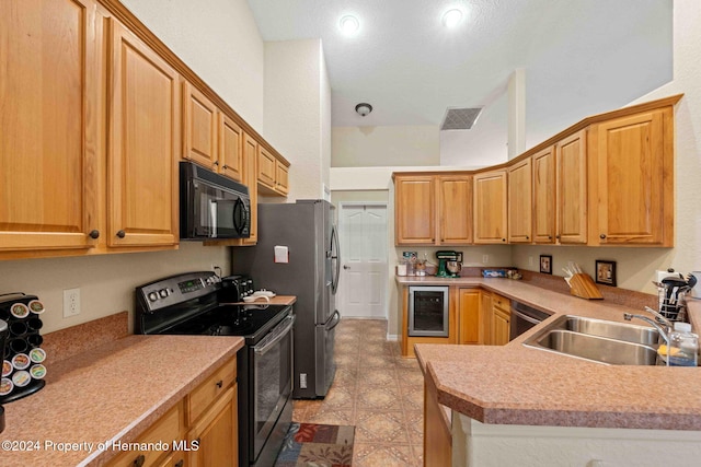 kitchen with kitchen peninsula, sink, wine cooler, and black appliances