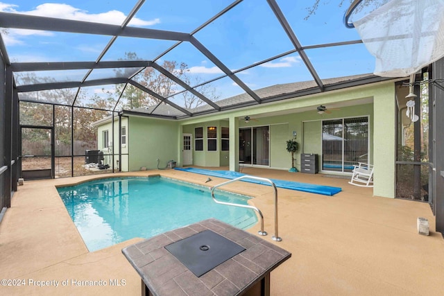 view of swimming pool with ceiling fan, a lanai, and a patio