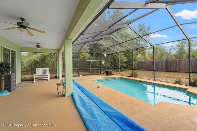 view of swimming pool featuring a lanai, a patio area, and ceiling fan