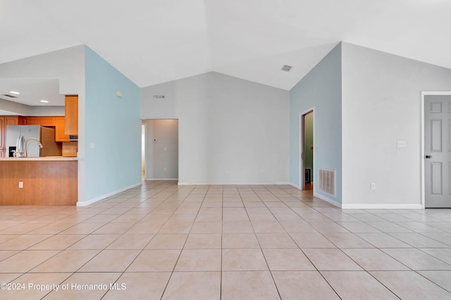 unfurnished living room with light tile patterned floors and vaulted ceiling