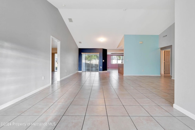 unfurnished living room featuring light tile patterned floors and high vaulted ceiling