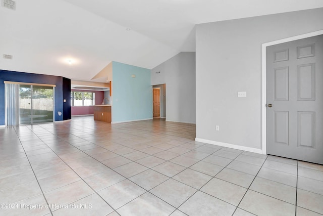 unfurnished living room with light tile patterned floors and lofted ceiling