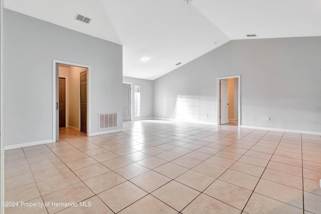 unfurnished room with light tile patterned floors and vaulted ceiling