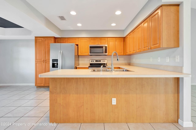 kitchen with kitchen peninsula, sink, stainless steel appliances, and light tile patterned flooring