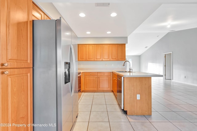 kitchen featuring sink, stainless steel appliances, kitchen peninsula, vaulted ceiling, and light tile patterned floors