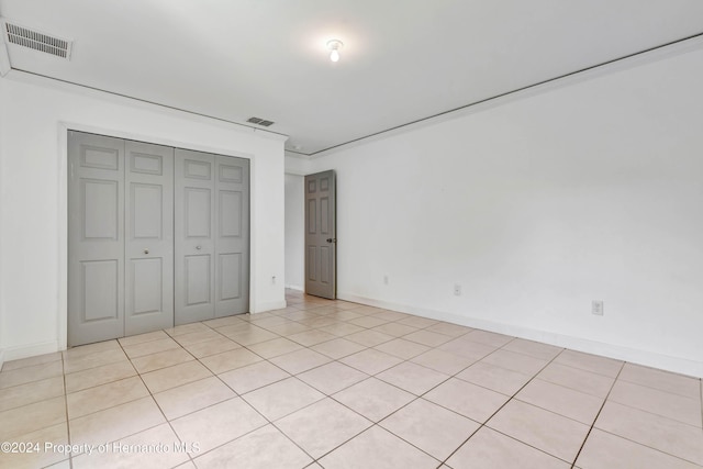 unfurnished bedroom featuring a closet and light tile patterned flooring