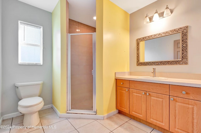 bathroom featuring tile patterned flooring, vanity, toilet, and a shower with shower door