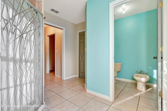 interior space featuring toilet, tile patterned floors, and a bidet