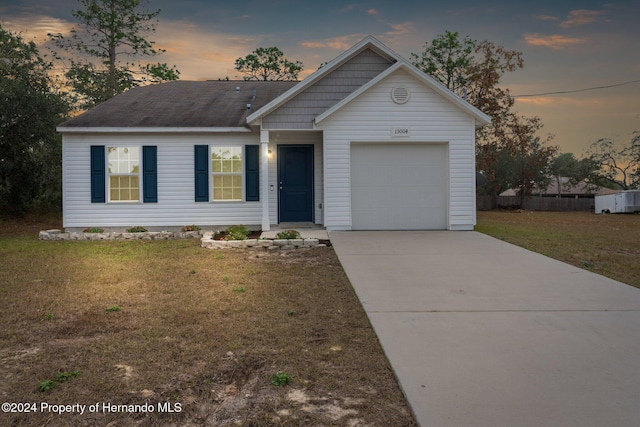 view of front facade with a yard and a garage