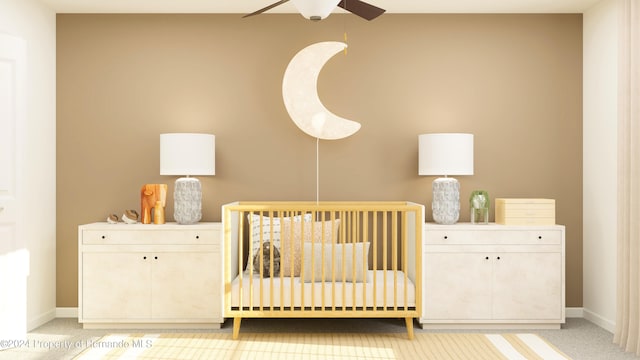 carpeted bedroom featuring ceiling fan and a crib