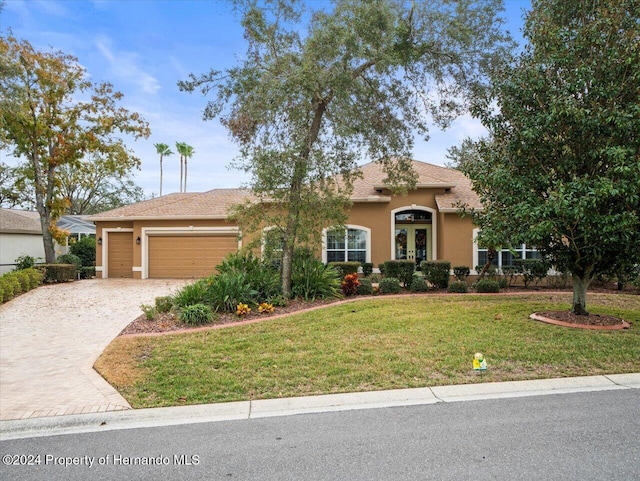 view of front of house featuring a front yard, french doors, and a garage