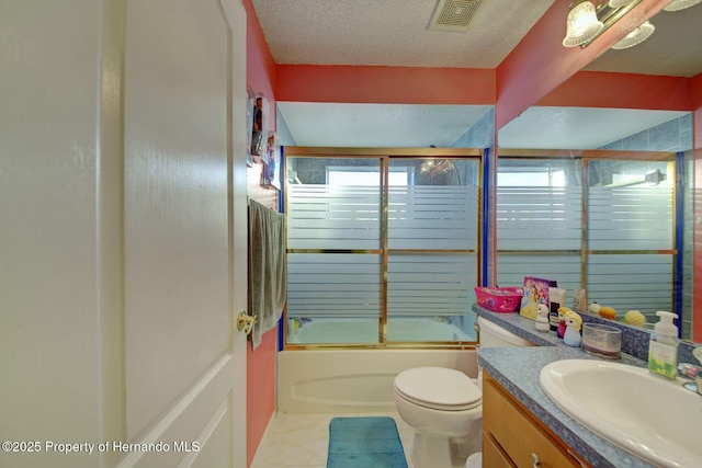 full bathroom featuring tile patterned flooring, enclosed tub / shower combo, a textured ceiling, toilet, and vanity