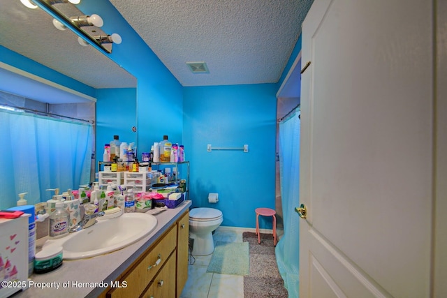 bathroom featuring vanity, a textured ceiling, and toilet