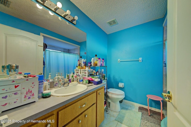 bathroom with vanity, a textured ceiling, tile patterned flooring, toilet, and curtained shower