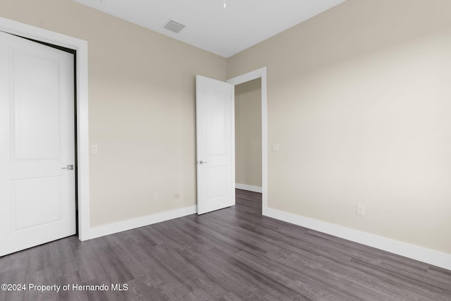 unfurnished bedroom with dark hardwood / wood-style floors